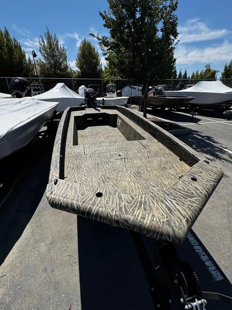Slide: The Image of 2025 Tracker Grizzly 1650 T Prairie Wings Edition boat in parking lot, camo design. - 3