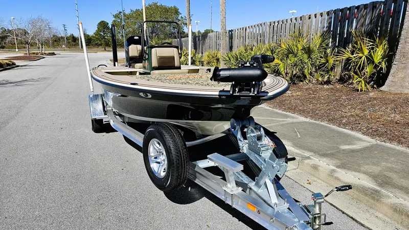Slide: The Image of 2025 Mako 18 Pro Skiff Backwater Edition on trailer, parked on a sunny street. - 5