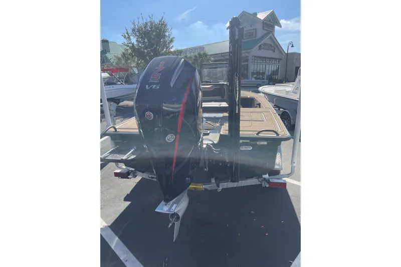 Slide: The Image of 2025 Mako 18 Pro Skiff Backwater Edition with powerful V6 engine in parking lot. - 2