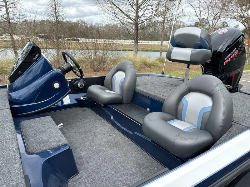 Slide: The Image of 2025 Nitro Z17 boat interior with gray and blue seating, steering console, and outboard motor. - 5