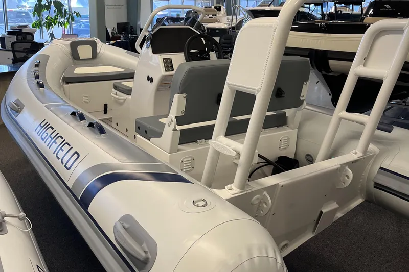 Slide: The Image of 2025 Highfield Classic 400 inflatable boat in showroom, featuring sleek design and modern seating. - 5