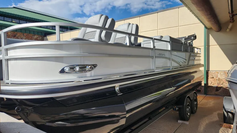 Slide: The Image of 2025 Ranger Reata 223FC pontoon boat displayed outdoors, showcasing sleek design and modern features. - 0