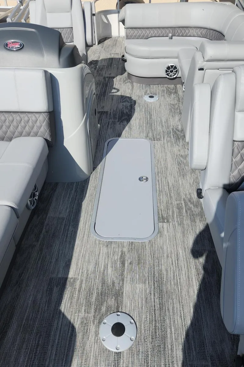 Slide: The Image of 2025 Ranger Reata 223FC boat interior with gray seating and carpeted flooring. - 1