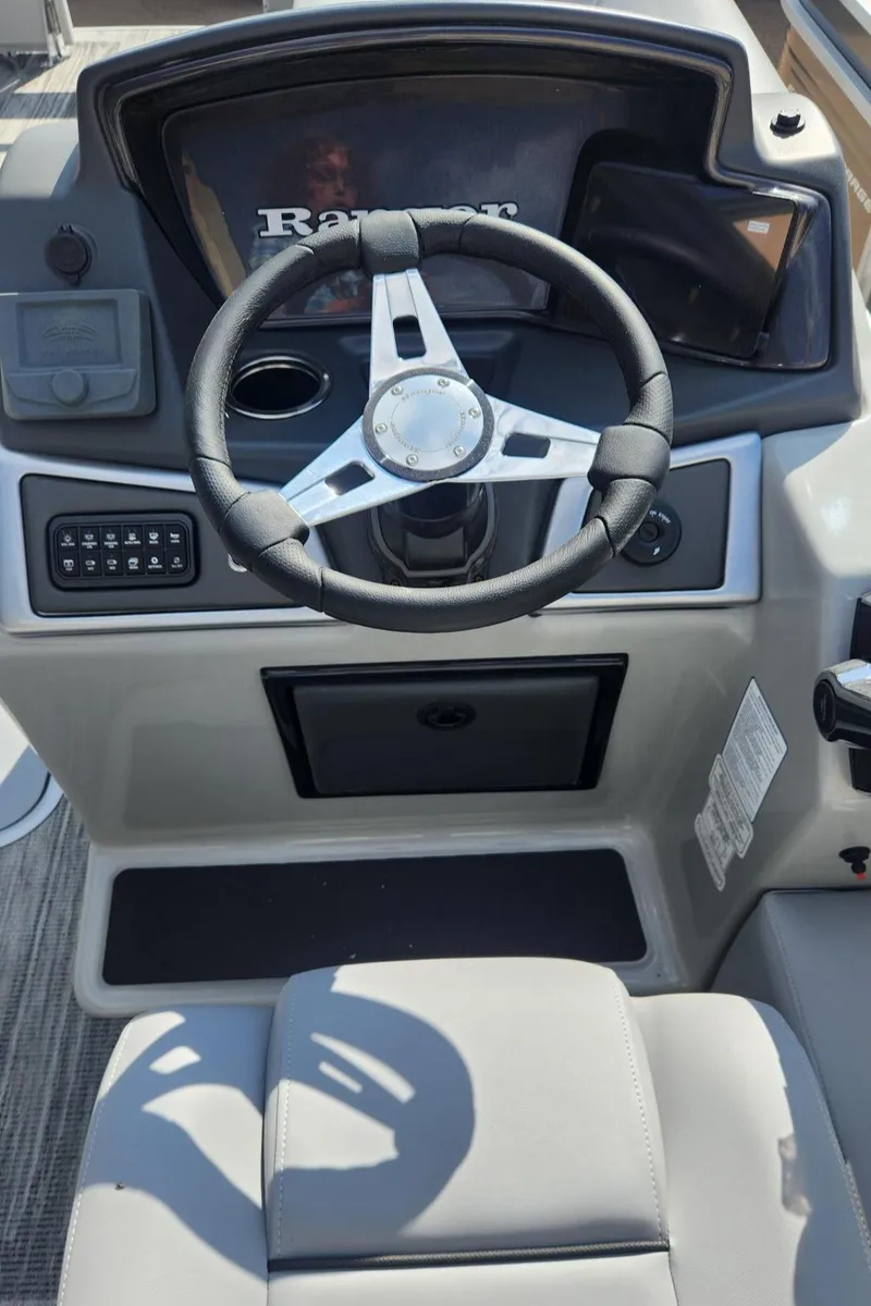 Slide: The Image of 2025 Ranger Reata 223FC boat dashboard with steering wheel and control panel. - 3