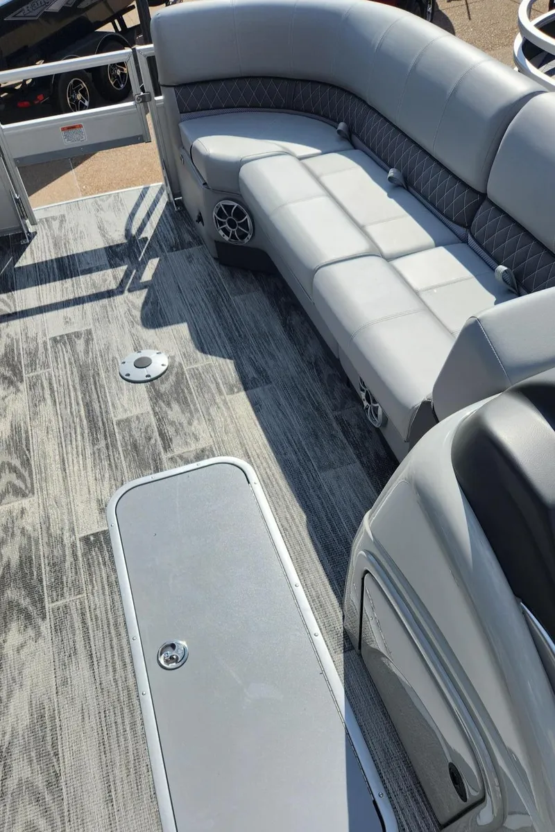 Slide: The Image of 2025 Ranger Reata 223FC boat interior with gray seating and wood-patterned flooring. - 4