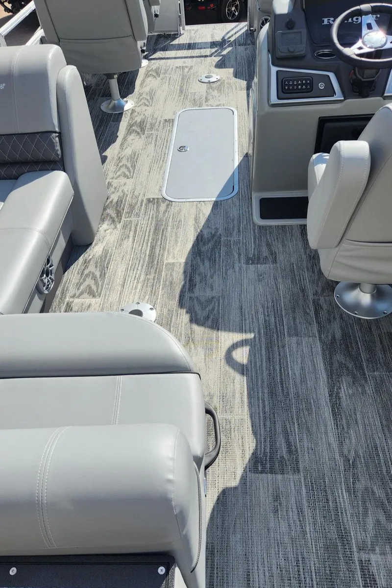 Slide: The Image of 2025 Ranger Reata 223FC boat interior with gray seating and wood-patterned flooring. - 6
