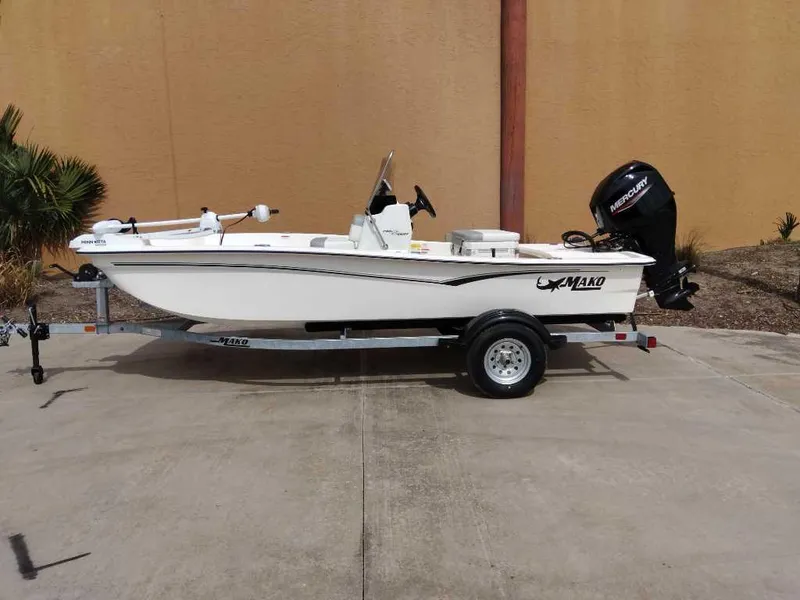 Slide: The Image of 2025 Mako Pro Skiff 15 CC boat on trailer, parked outdoors. - 0