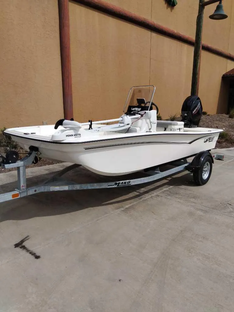 Slide: The Image of 2025 Mako Pro Skiff 15 CC boat on trailer, parked outdoors. - 1