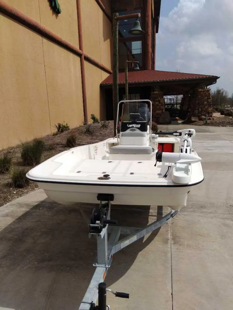 Slide: The Image of 2025 Mako Pro Skiff 15 CC boat on trailer, parked outdoors. - 2