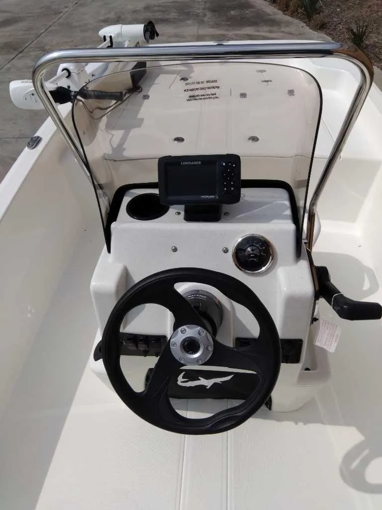 Slide: The Image of 2025 Mako Pro Skiff 15 CC boat console with steering wheel and navigation system. - 3