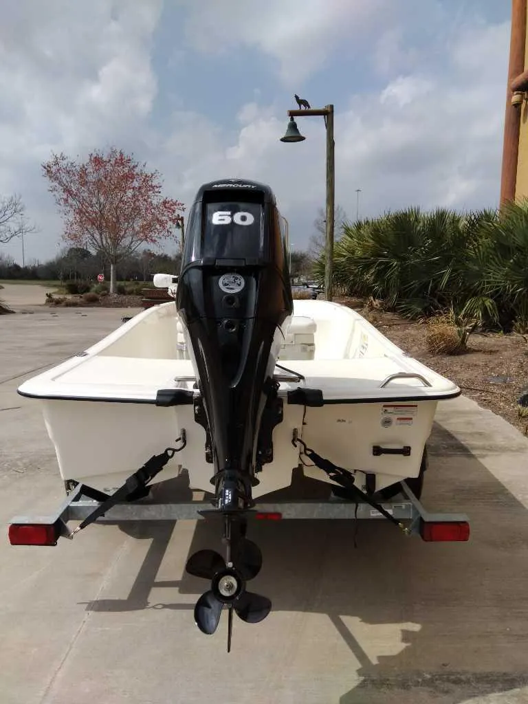 Slide: The Image of 2025 Mako Pro Skiff 15 CC boat with 60 HP outboard motor on trailer. - 6