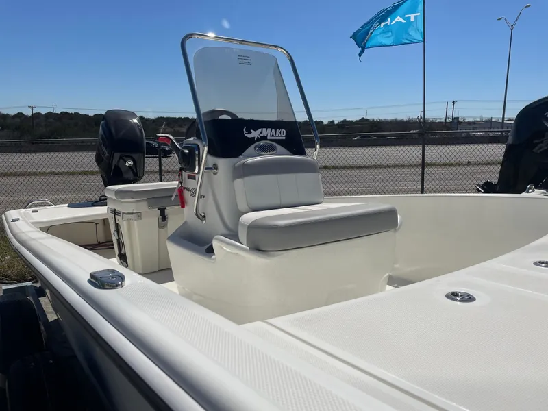 Slide: The Image of 2025 Mako Pro Skiff 15 CC boat with center console and seating, displayed outdoors. - 7