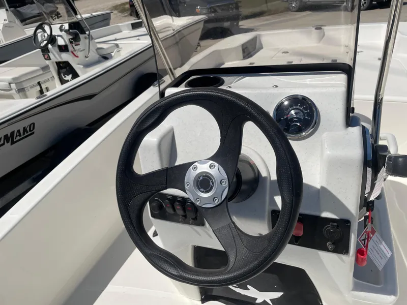 Slide: The Image of 2025 Mako Pro Skiff 15 CC steering console with black wheel and controls. - 8