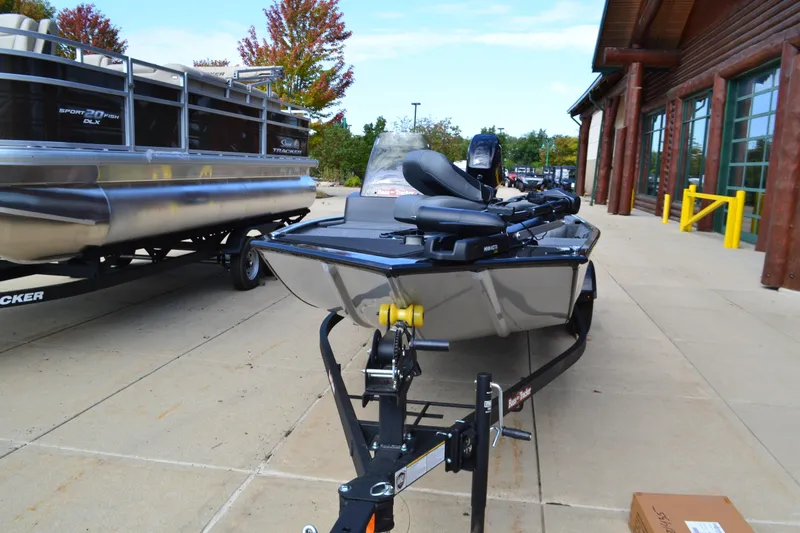 Slide: The Image of 2025 Tracker Bass Tracker Classic XL boat on trailer, parked outside a building. - 2