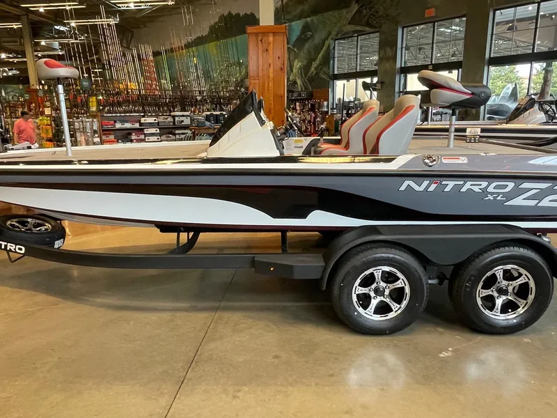 Slide: The Image of 2025 Nitro Z20 XL Pro boat displayed indoors, featuring sleek design and dual-axle trailer. - 0