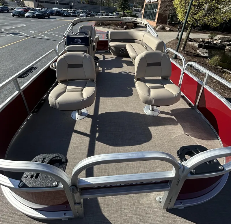 Slide: The Image of 2025 Sun Tracker Bass Buggy 16 XL Select pontoon boat with beige seating and red exterior. - 2