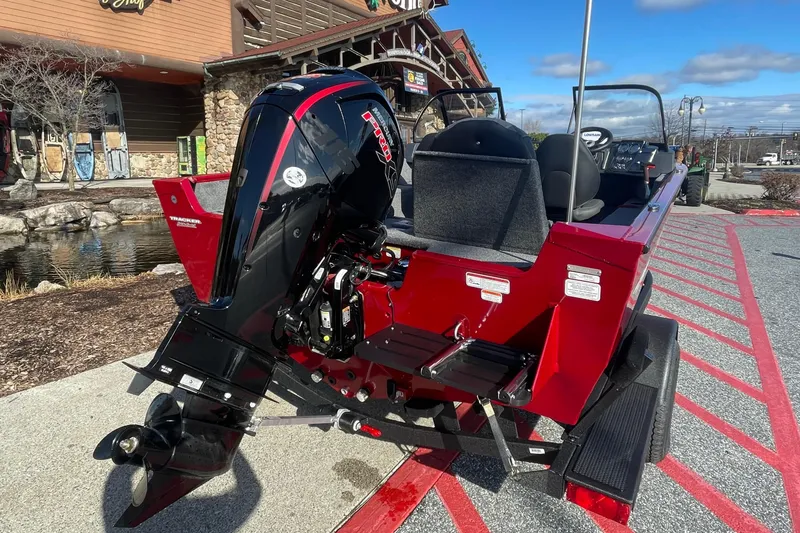Slide: The Image of 2025 Tracker Pro Guide V-175 Combo boat with powerful outboard motor, parked outdoors. - 2