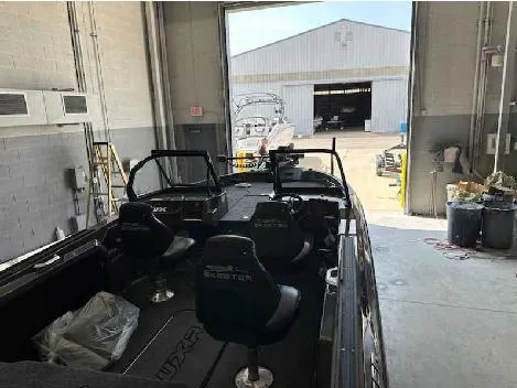 Slide: The Image of 2025 Skeeter WXR 2060F boat in a garage, with open door to a boatyard. - 2