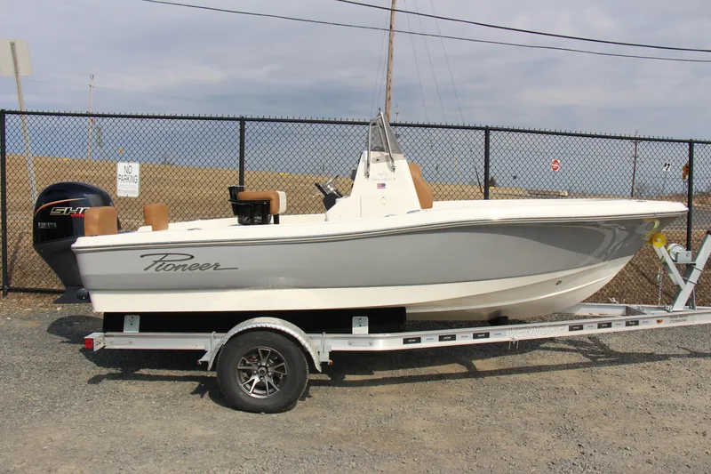 Slide: The Image of 2025 Pioneer 180 Sportfish boat on trailer, parked outdoors. - 2