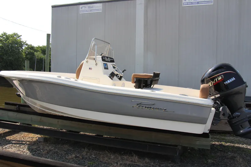 Slide: The Image of 2025 Pioneer 180 Sportfish boat with Yamaha outboard motor, docked outdoors. - 5
