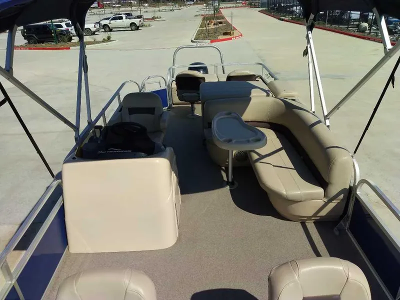 Slide: The Image of 2017 Sun Tracker Fishing Barge 22 XP3 interior with seating and canopy in a parking lot. - 3
