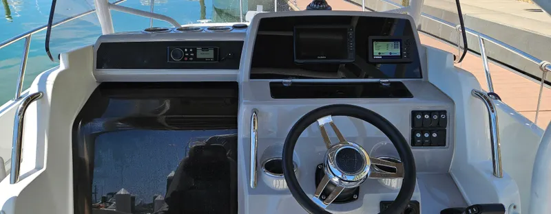 Slide: The Image of 2019 Jeanneau Leader 7.5 CC boat dashboard with steering wheel and navigation controls. - 16