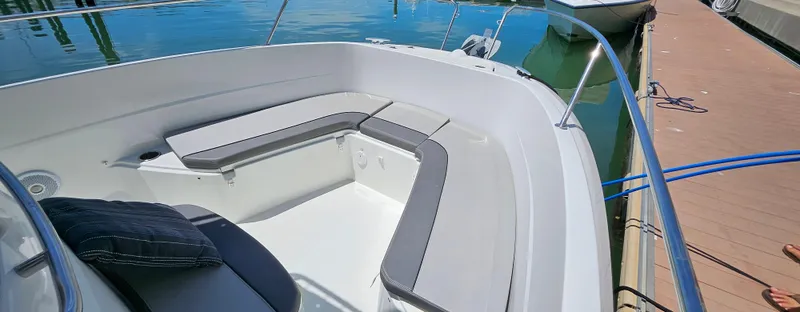 Slide: The Image of 2019 Jeanneau Leader 7.5 CC boat interior with cushioned seating at dock. - 18