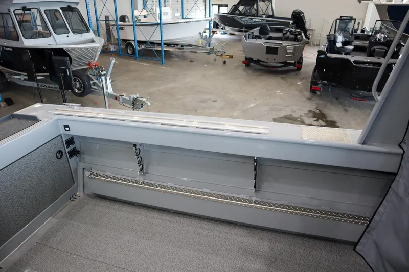Slide: The Image of 2025 Hewescraft 240 Ocean Pro ET HT boat interior in showroom, showcasing storage and seating. - 10