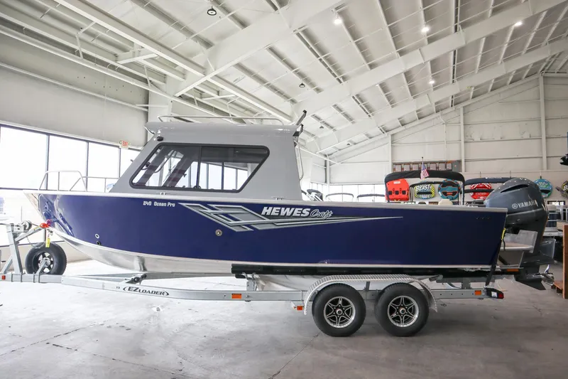 Slide: The Image of 2025 Hewescraft 240 Ocean Pro ET HT boat on trailer in indoor showroom. - 3