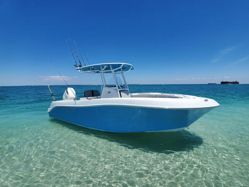 Slide: The Image of 2022 Aquasport 2300 Center Console boat on clear blue water under a sunny sky. - 0