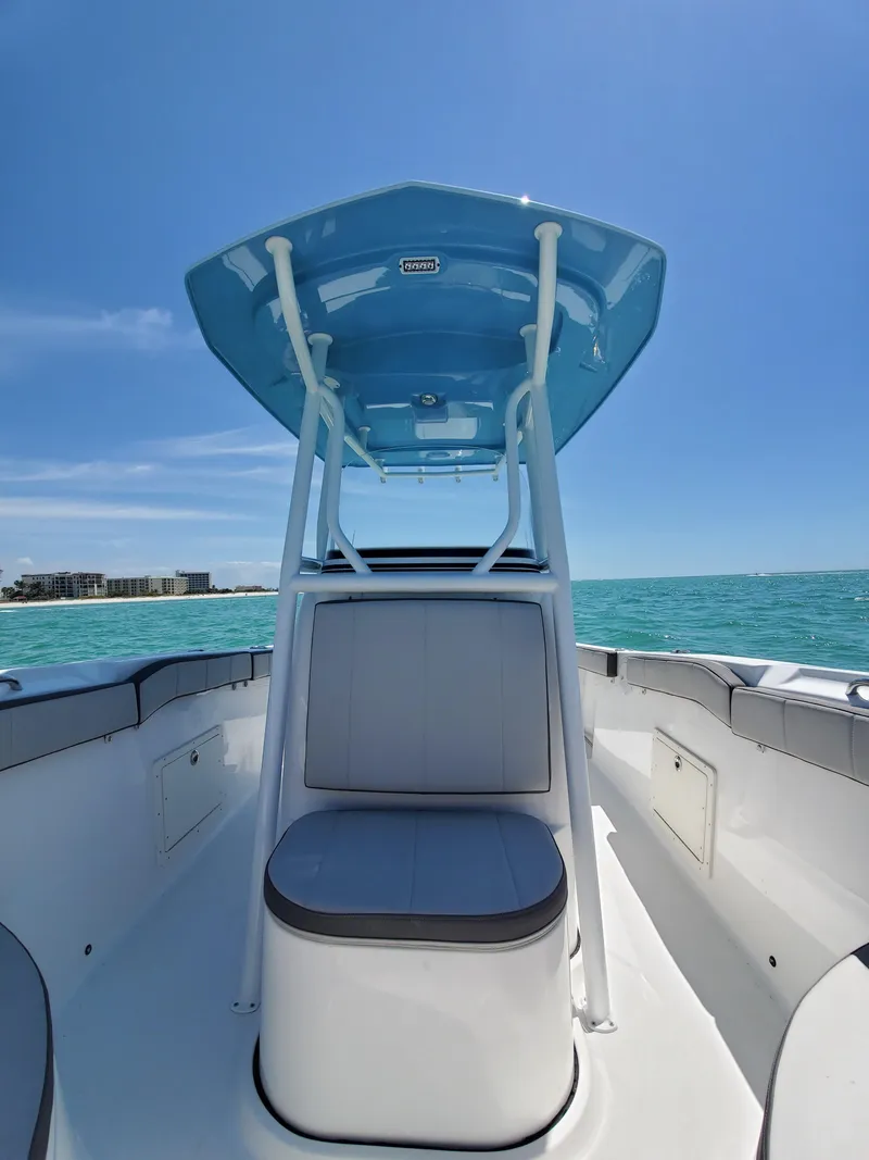 Slide: The Image of 2022 Aquasport 2300 Center Console boat on clear blue water under sunny sky. - 2
