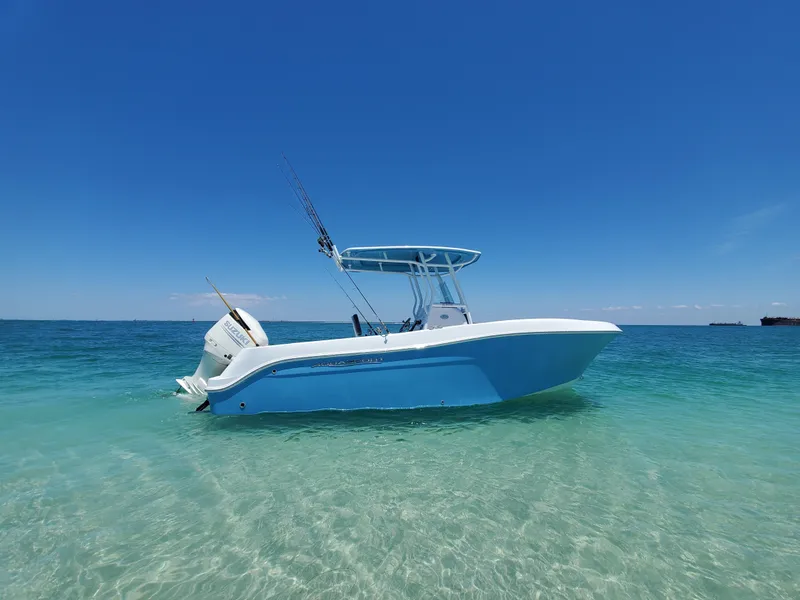 Slide: The Image of 2022 Aquasport 2300 Center Console boat on clear blue water under a sunny sky. - 4