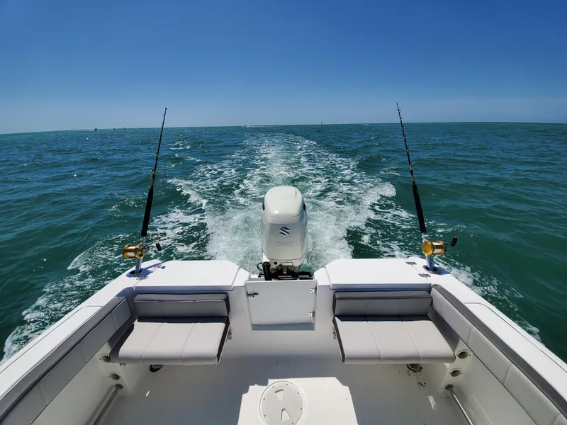 Slide: The Image of Aquasport 2300 Center Console 2022 boat cruising on open water with fishing rods. - 5