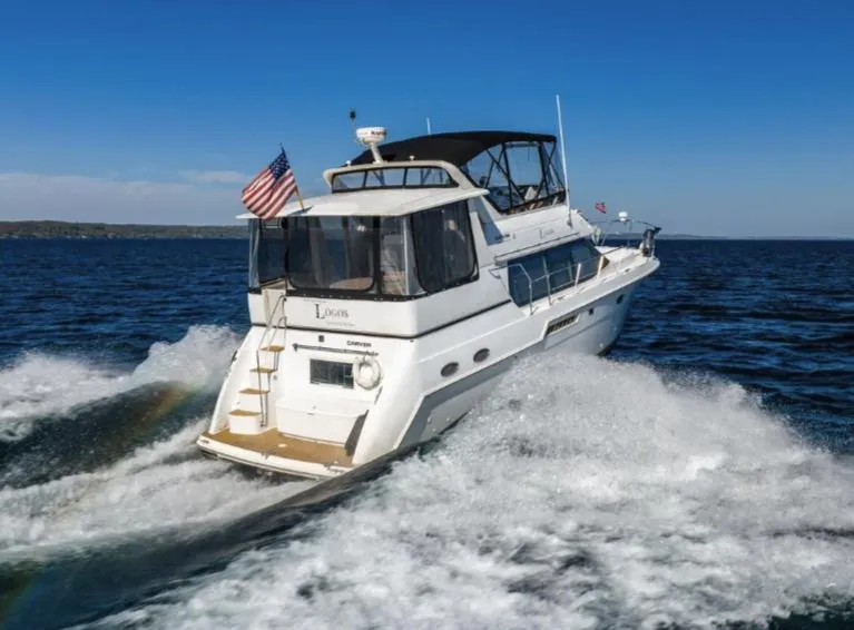 Slide: The Image of 2000 Carver 406 Aft Cabin Motor Yacht cruising on open water. - 1