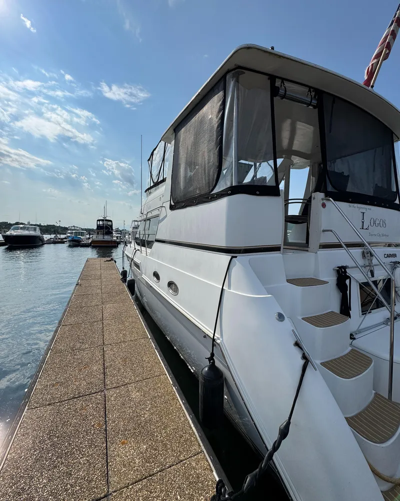 Slide: The Image of 2000 Carver 406 Aft Cabin Motor Yacht docked under a clear blue sky. - 10