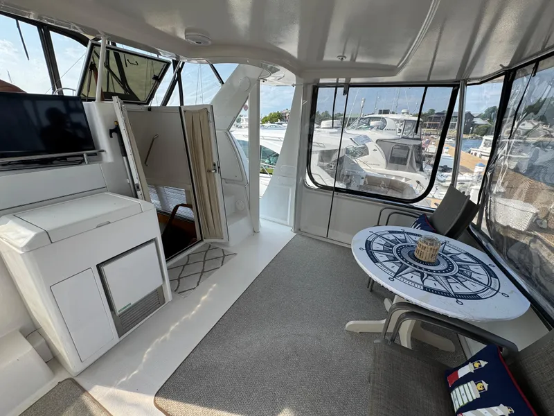 Slide: The Image of 2000 Carver 406 Aft Cabin Motor Yacht interior with seating and nautical-themed table. - 14