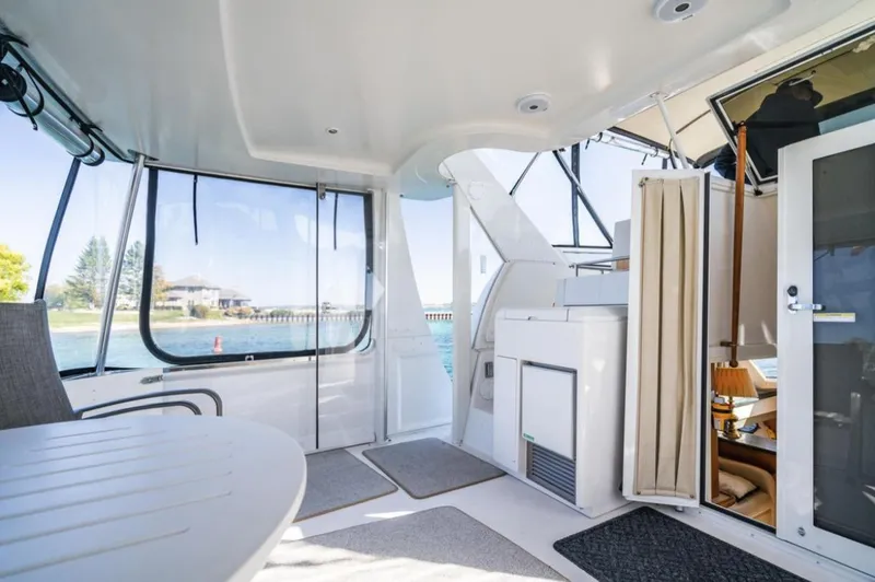 Slide: The Image of 2000 Carver 406 Aft Cabin Motor Yacht interior with spacious seating and scenic water views. - 18