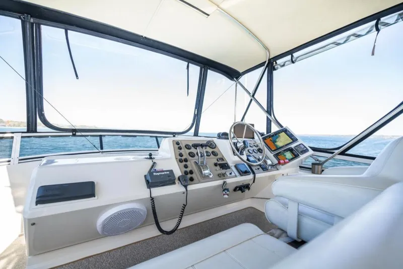 Slide: The Image of 2000 Carver 406 Aft Cabin Motor Yacht helm with navigation controls and seating. - 20