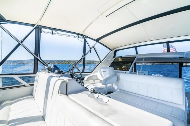 Slide: The Image of 2000 Carver 406 Aft Cabin Motor Yacht interior with white seating and scenic water view. - 24