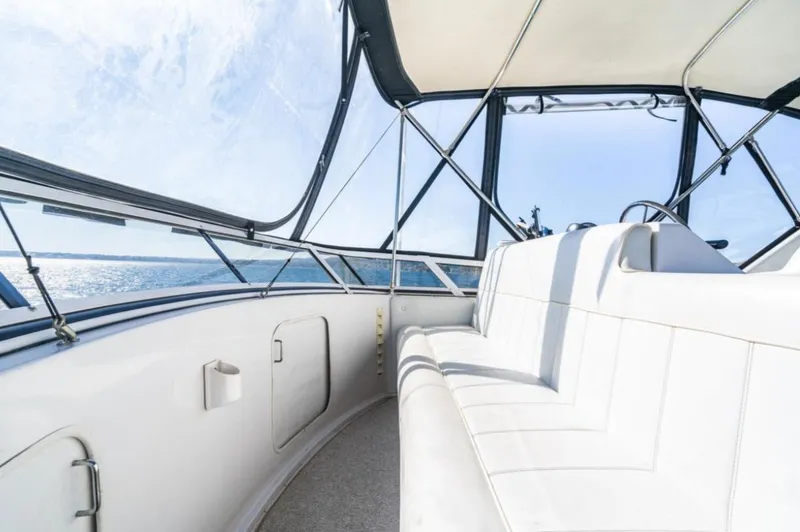 Slide: The Image of 2000 Carver 406 Aft Cabin Motor Yacht interior with white seating and panoramic windows. - 25