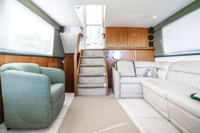 Slide: The Image of Interior of 2000 Carver 406 Aft Cabin Motor Yacht with plush seating and wooden accents. - 34