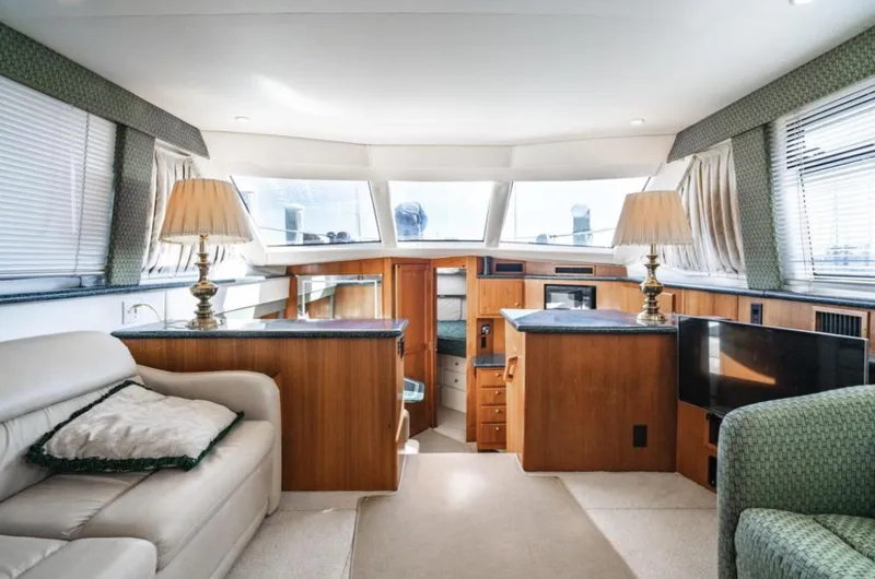 Slide: The Image of Interior of 2000 Carver 406 Aft Cabin Motor Yacht, featuring elegant wood finishes and cozy seating. - 35