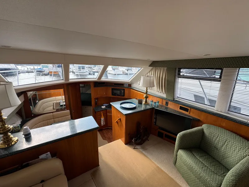 Slide: The Image of Interior of 2000 Carver 406 Aft Cabin Motor Yacht, featuring spacious seating and large windows. - 37