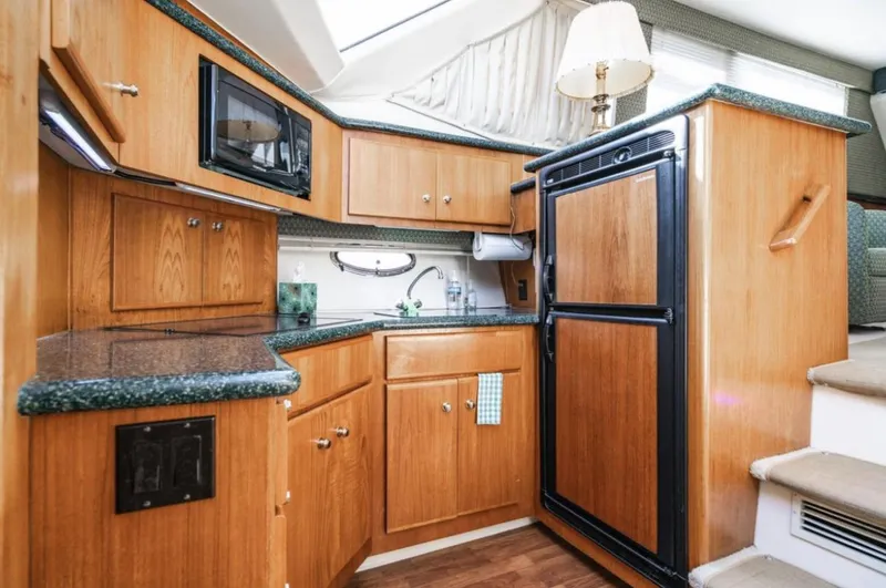 Slide: The Image of 2000 Carver 406 Aft Cabin Motor Yacht kitchen with wood cabinetry and modern appliances. - 43