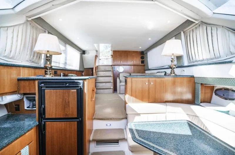 Slide: The Image of Interior of 2000 Carver 406 Aft Cabin Motor Yacht, featuring elegant wood cabinetry and cozy seating. - 45
