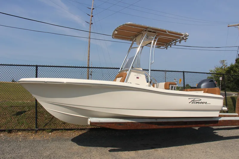 Slide: The Image of 2025 Pioneer 180 Islander boat with T-top, parked on a trailer. - 0