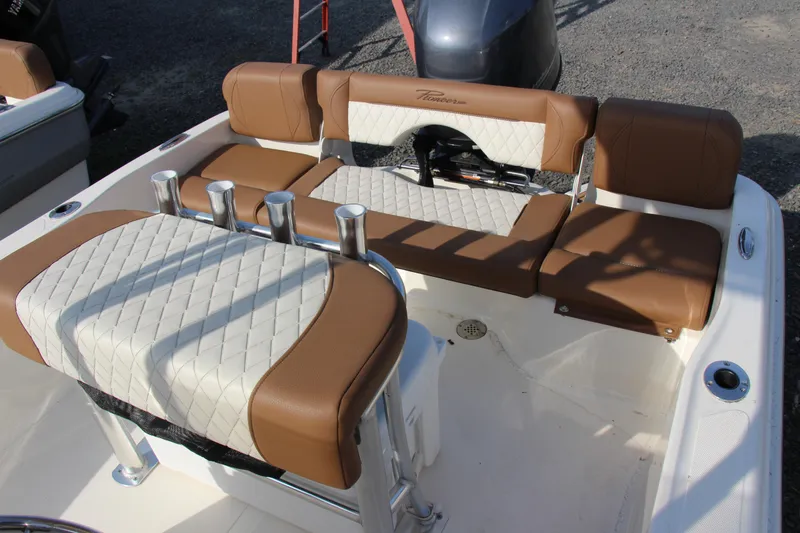 Slide: The Image of 2025 Pioneer 180 Islander boat interior with brown and white cushioned seating. - 11