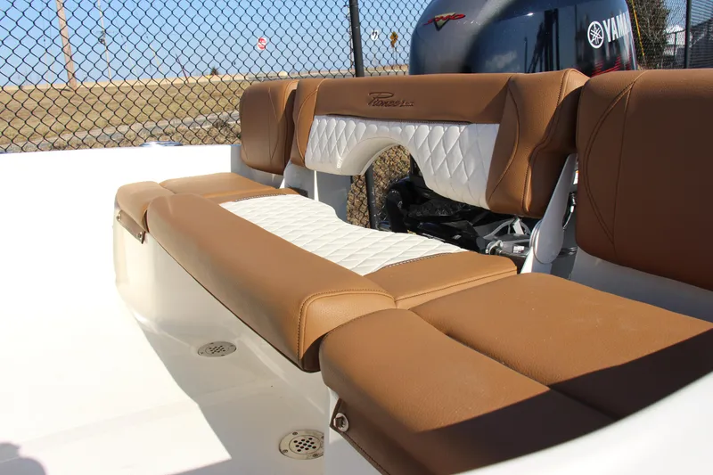 Slide: The Image of 2025 Pioneer 180 Islander boat interior with tan and white cushioned seating. - 13
