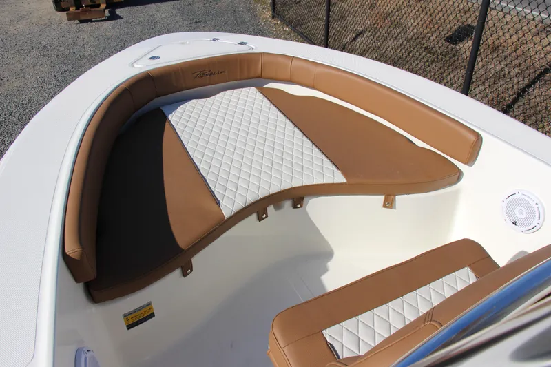 Slide: The Image of 2025 Pioneer 180 Islander boat interior with tan and white cushioned seating. - 6