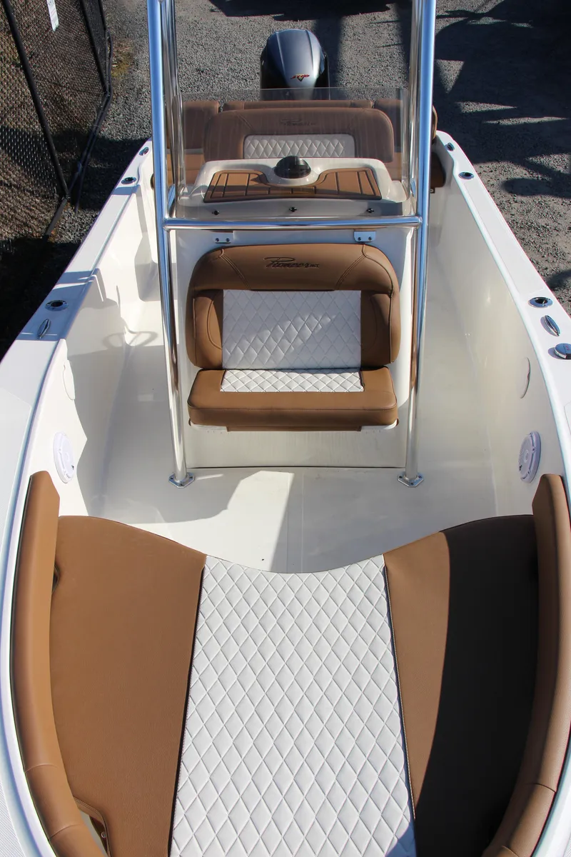 Slide: The Image of 2025 Pioneer 180 Islander boat interior with tan and white seating, featuring a center console. - 8